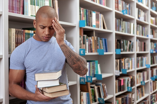 Junger Mann in der Bibliothek oder im Buchladen