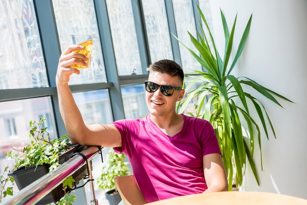 Junger Mann in der Kneipe. Bier trinken, Pizza essen.