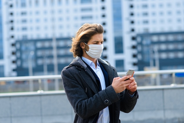 Junger Mann in einer medizinischen Maske draußen