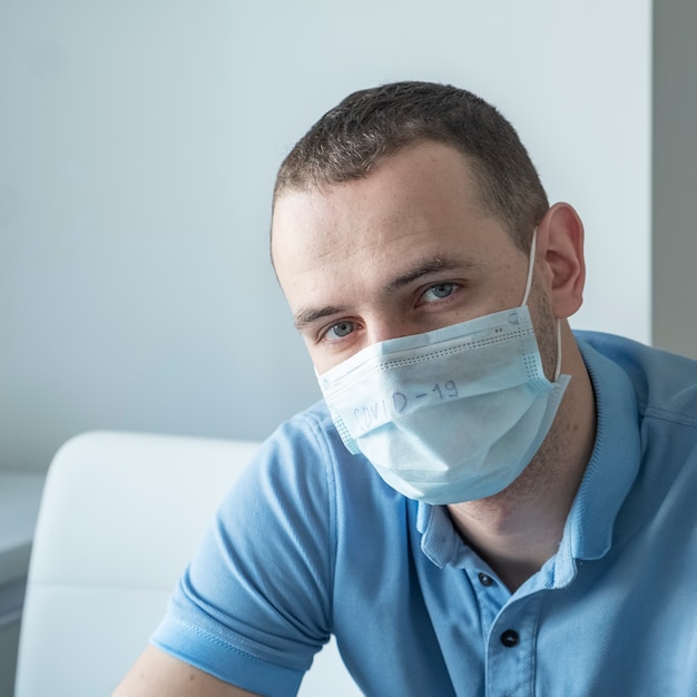 Junger Mann in einer medizinischen Schutzmaske. Stoppen Sie die Coronavirus-Pandemie.