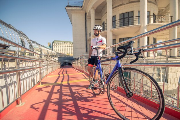 Junger Mann in sportlicher Kleidung mit einem Fahrrad