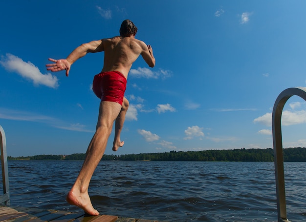 Junger Mann ins Wasser springen