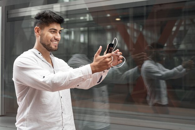 Junger Mann lächelt glücklich bei Videoanrufen mit Smartphone in der Stadt