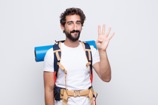 Junger Mann lächelt und sieht freundlich aus, zeigt Nummer vier oder vierten mit der Hand nach vorne, Countdown