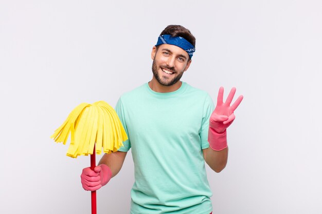 Junger Mann lächelt und sieht freundlich aus, zeigt Nummer zwei oder Sekunde mit der Hand nach vorne, Countdown