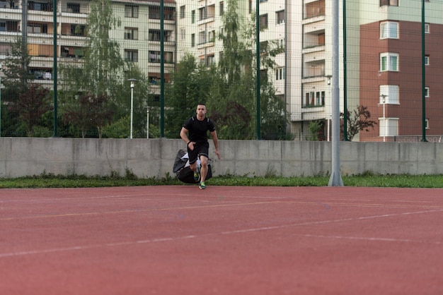 Junger Mann läuft mit Fallschirm auf dem Sportplatz