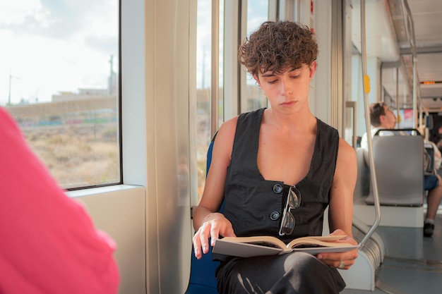 Foto junger mann liest in einem zug ein buch