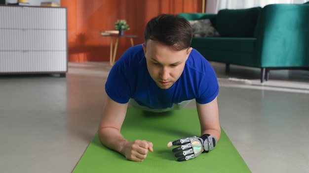 Junger Mann mit bionischer Hand trainiert auf dem Boden der Wohnung
