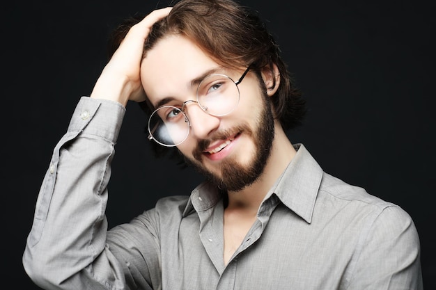 Junger Mann mit Brille auf schwarzem Hintergrund