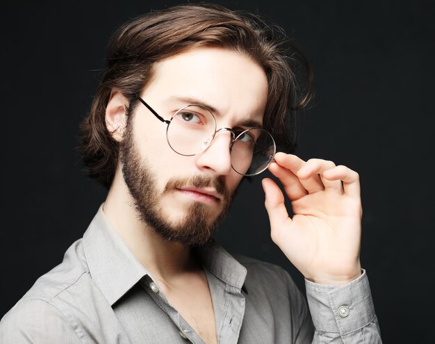 Junger Mann mit Brille auf schwarzem Hintergrund