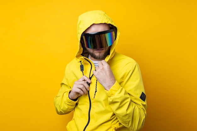 Junger Mann mit Cyberpunk-Brille in einer gelben Jacke auf gelbem Hintergrund