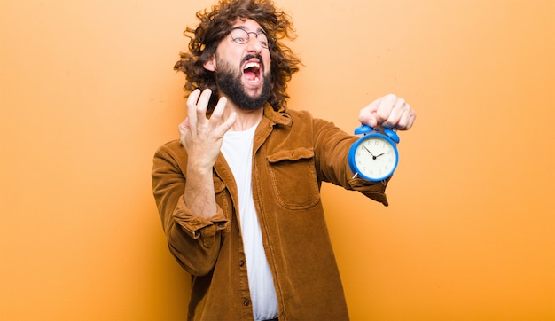 Foto junger mann mit dem verrückten haar in der bewegung und in einem wecker