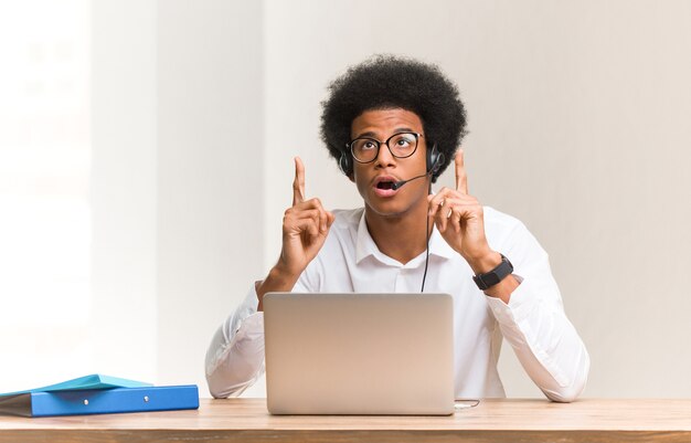 Junger Mann mit der Brille zeigt nach oben