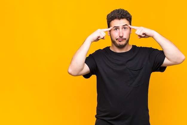 Junger Mann mit einem ernsten und konzentrierten Blick, Brainstorming und Nachdenken über ein herausforderndes Problem