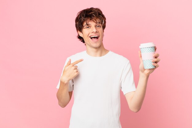 Junger Mann mit einem Kaffee, der sich glücklich fühlt und aufgeregt auf sich selbst zeigt