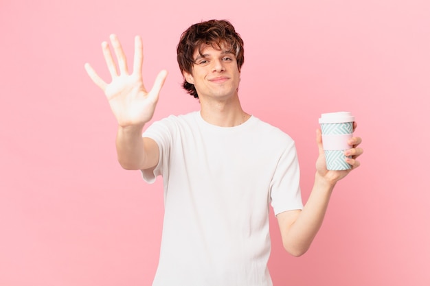 Junger Mann mit einem Kaffee lächelt und sieht freundlich aus und zeigt Nummer fünf