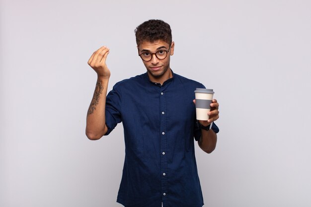 Junger Mann mit einer Kaffeezubereitungs- oder Geldgeste