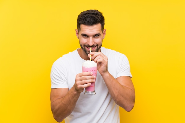 Junger Mann mit Erdbeermilchshake