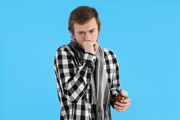 Junger Mann mit Erkältung auf blauem Hintergrund
