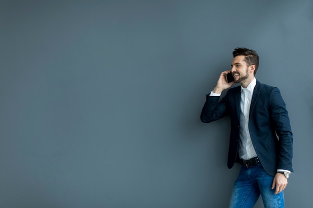 Junger Mann mit Handy im Büro