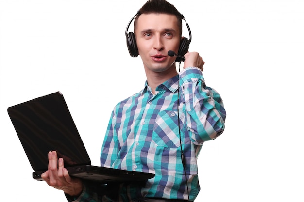 Junger Mann mit Headset hält Laptop - Call-Center-Mann mit Headset und Laptop-Computer auf weißer Wand