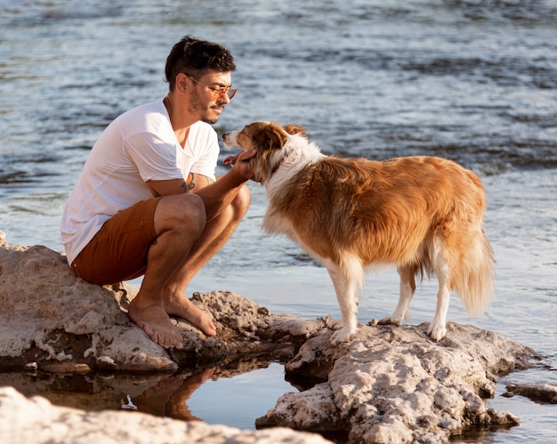 Foto junger mann mit hund am meer