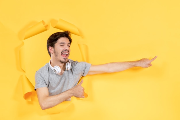 junger Mann mit Kopfhörern auf gelbem isoliertem Hintergrundmusik-Ultraschall-Audio