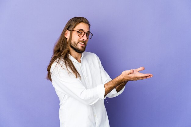 Junger Mann mit langem Haarblick, der einen Kopienraum auf einer Handfläche hält.