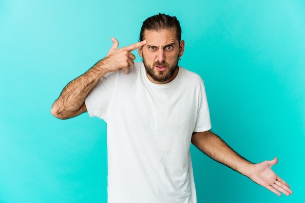 Junger Mann mit langem Haarblick zeigt eine enttäuschende Geste mit Zeigefinger.