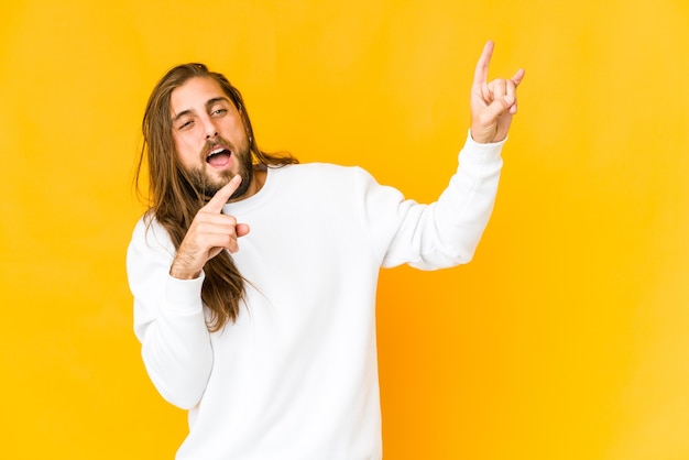 Junger Mann mit langen Haaren sehen tanzen und Spaß haben.