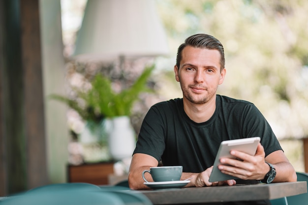 Junger Mann mit Laptop arbeitet von zu Hause aus