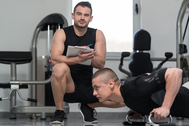 Junger Mann mit Personal Trainer Übung Push Up