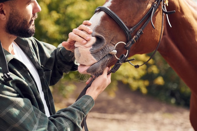 Foto junger mann mit pferd ist draußen