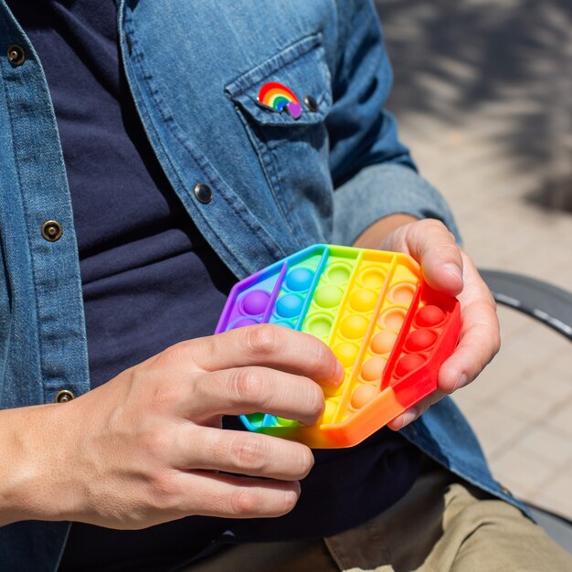 Junger Mann mit Regenbogen knall es zappeln