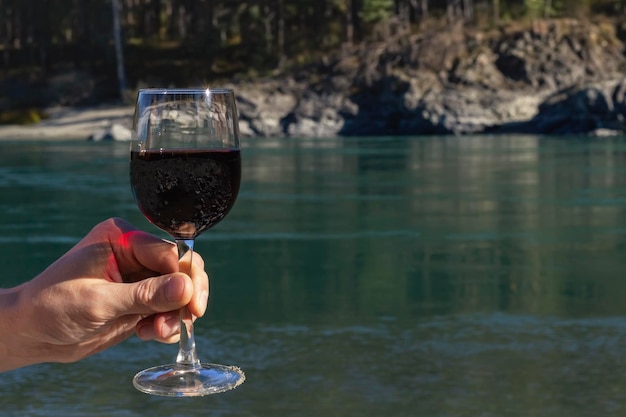 Junger Mann mit Rotweinglas Platz für Text Feiern mit einem Glas Wein in der Natur