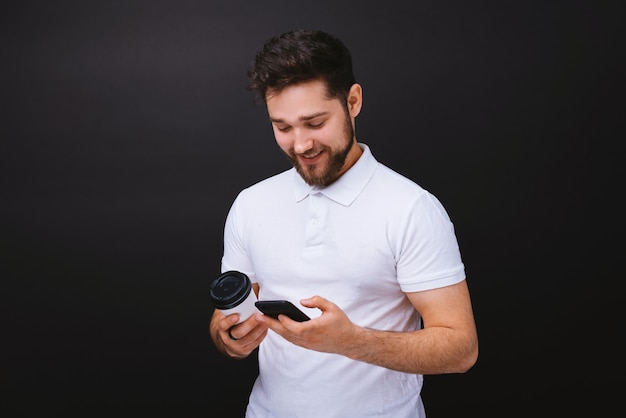 Junger Mann mit Smartphone und Kaffee