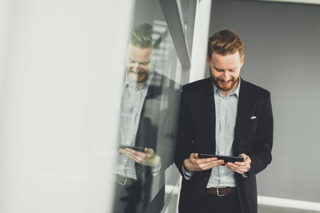 Junger Mann mit Tablette im Büro