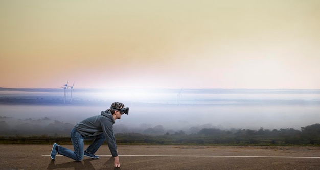 Junger Mann mit VR-Headset in startbereiter Position auf einer Straße. Gemischte Medien