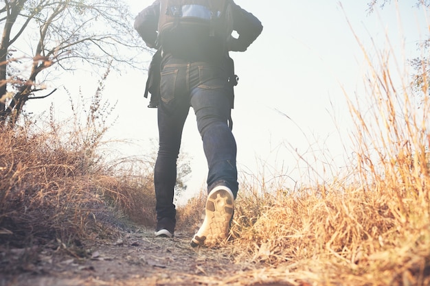 Junger Mann-Reisender mit dem entspannenden Rucksack im Freien