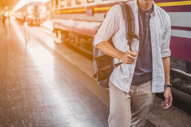 Junger Mann reisender Rucksacktourist im Bahnhof. Reisekonzept.