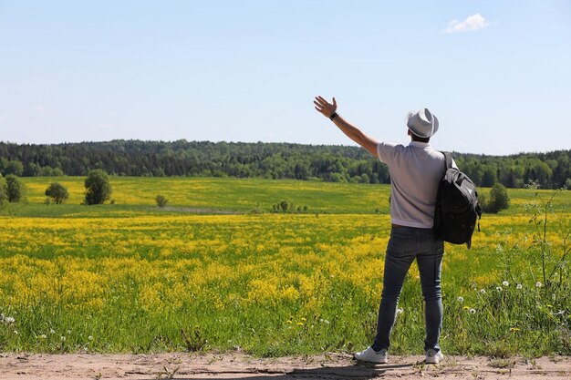 Junger Mann reist mit einem Rucksack an einem Sommertag im Freien