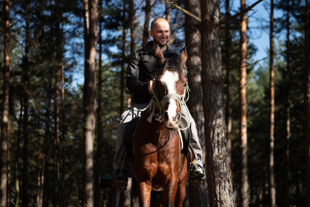 Junger Mann sitzt draußen auf einem Pferd