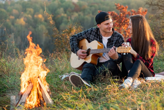 Junger Mann spielt auf der Gitarre für seine schöne Freundin.