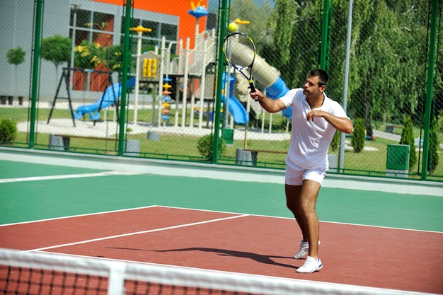 junger Mann spielt im Freien Tennis