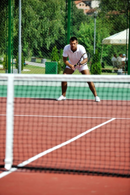 junger Mann spielt im Freien Tennis