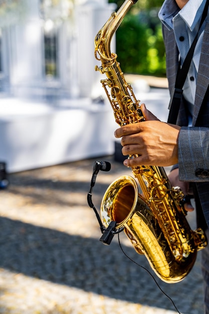 Junger Mann spielt Saxophon bei der Hochzeit Unscharfer Hintergrund Selektiver Fokus