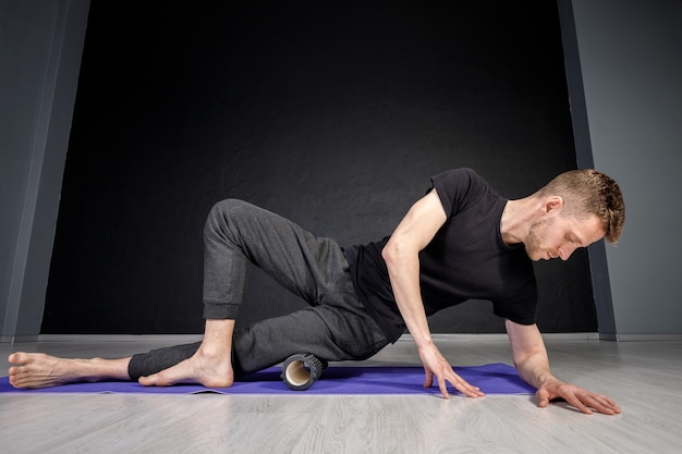 Junger Mann streckt sich im Fitnessstudio