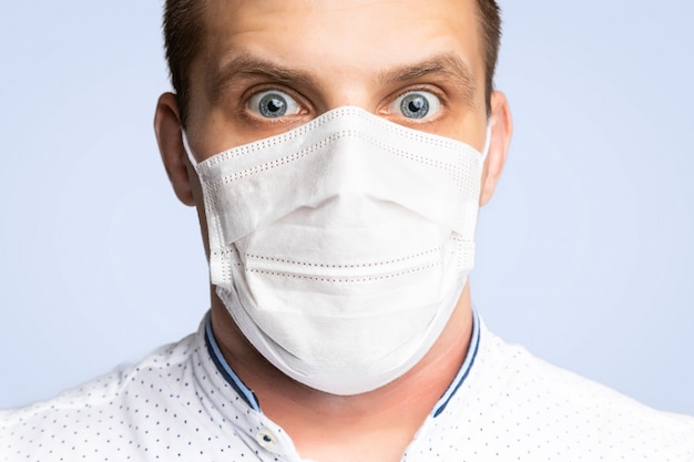 Junger Mann trägt Masken, um Luftverschmutzung, Dunst und PM 2,5 Staub- und Rauchverschmutzung auf Weiß zu verhindern. Medizinischer Schutz gegen durch die Luft übertragene Krankheiten, Coronavirus. Der Mensch hat Angst vor der Grippe