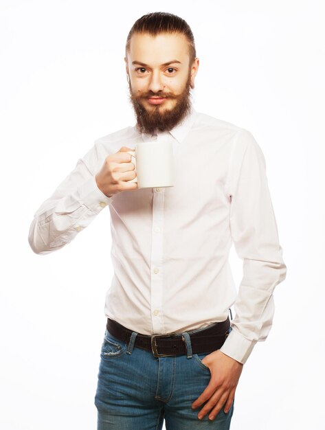 Junger Mann trinkt eine Tasse Kaffee oder Tee isoliert auf weißem Hintergrund