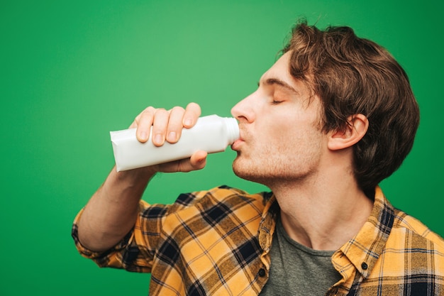 Junger Mann trinkt Milch mit Vergnügen